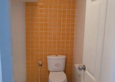 Bathroom with orange tiled wall and white fixtures