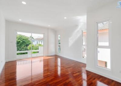 Spacious living room with large windows and wooden flooring