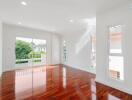 Spacious living room with large windows and wooden flooring