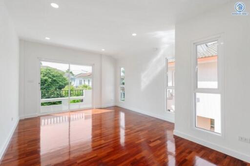 Spacious living room with large windows and wooden flooring