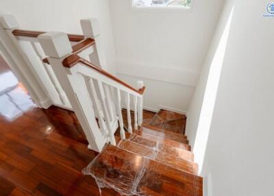 Staircase with wooden steps and white railings