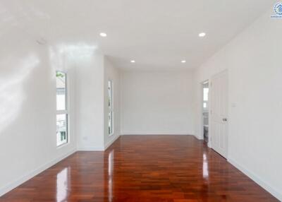 Spacious living room with polished hardwood floors and recessed lighting