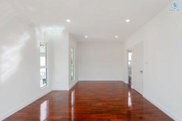 Spacious living room with polished hardwood floors and recessed lighting