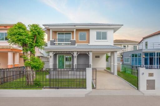 Front view of a two-story house with a gated driveway