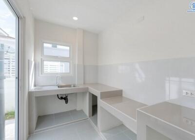 Minimalist kitchen with white walls and a window