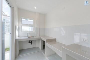 Minimalist kitchen with white walls and a window