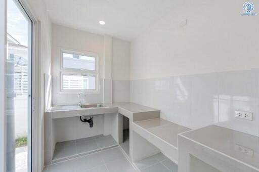 Minimalist kitchen with white walls and a window