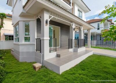 Modern two-story house exterior with front porch and lawn