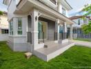 Modern two-story house exterior with front porch and lawn