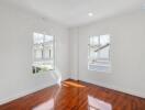 Empty bedroom with hardwood floors and large windows