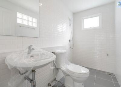 Clean and modern bathroom with white tiles, a sink, toilet, and shower