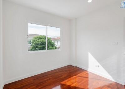 Bright bedroom with wooden floor and large window