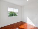 Bright bedroom with wooden floor and large window