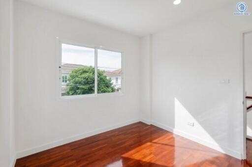 Bright bedroom with wooden floor and large window