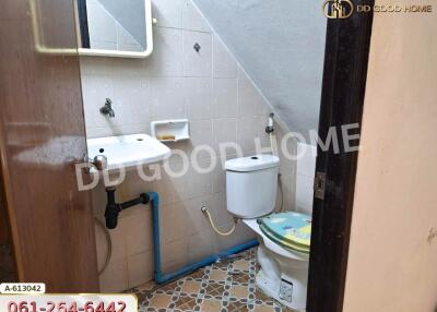 Small bathroom with sink and toilet under staircase