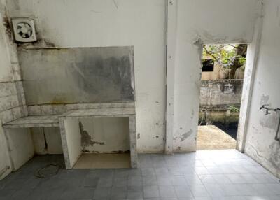 Empty kitchen with damaged walls and floor