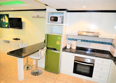 Modern kitchen with green refrigerator and built-in appliances