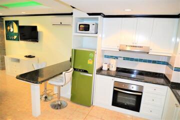 Modern kitchen with green refrigerator and built-in appliances