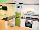 Modern kitchen with green refrigerator and built-in appliances