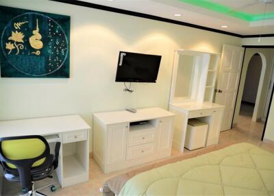 Modern bedroom with desk and mounted TV