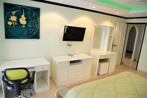 Modern bedroom with desk and mounted TV