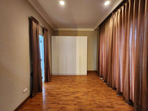 Spacious bedroom with wardrobe and wooden flooring