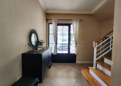 Spacious entryway with a modern console table, mirror, and staircase