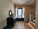 Spacious entryway with a modern console table, mirror, and staircase