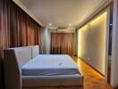 Modern bedroom with wooden flooring and ambient lighting