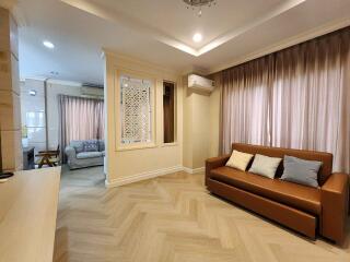 Modern living room with a brown sofa and light wood flooring