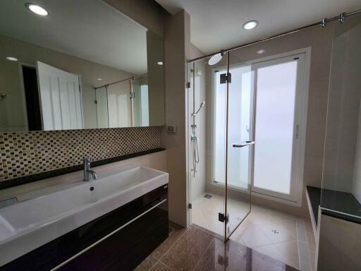 Modern bathroom with large sink, mirror, and glass shower enclosure