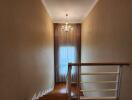 Staircase with chandelier and window