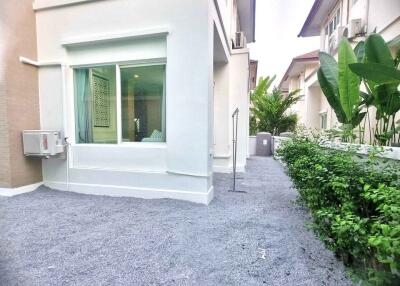 Side view of the house with plants and gravel pathway