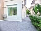 Side view of the house with plants and gravel pathway