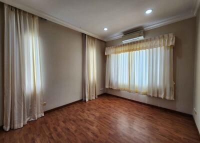 Empty bedroom with wooden flooring and curtains