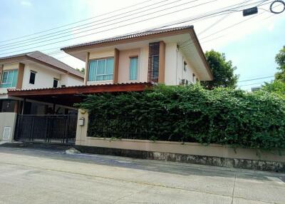 Front view of a two-story house with garage and greenery