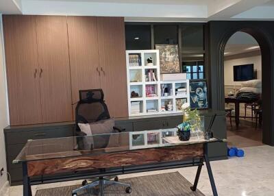 Modern home office with a glass-top desk and cabinetry