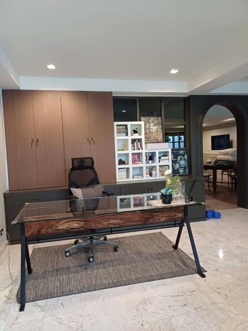 Modern home office with a glass-top desk and cabinetry