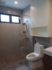 Modern bathroom with glass shower enclosure and tiled walls