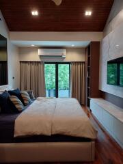 spacious bedroom with wooden ceiling and modern decor