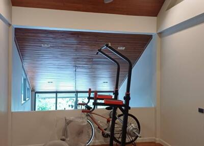 Home gym with exercise equipment and wooden ceiling