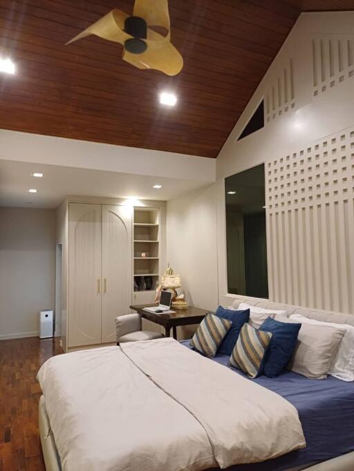 Modern bedroom with wooden ceiling and decorative pillows