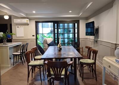 spacious dining area with table and chairs, adjacent to a well-lit space