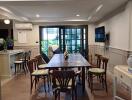 spacious dining area with table and chairs, adjacent to a well-lit space