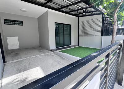 Covered outdoor space with artificial grass and concrete area