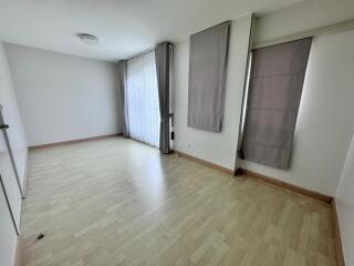 Spacious empty living room with large windows and curtains