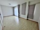 Spacious empty living room with large windows and curtains