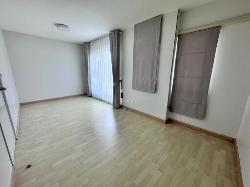 Spacious empty living room with large windows and curtains