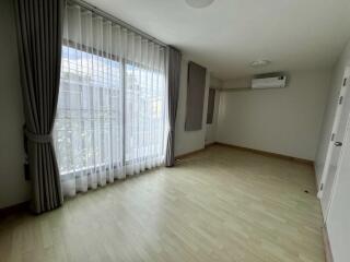 Spacious bedroom with large window and wood floor