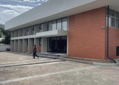 Two-story commercial building front view with parking area